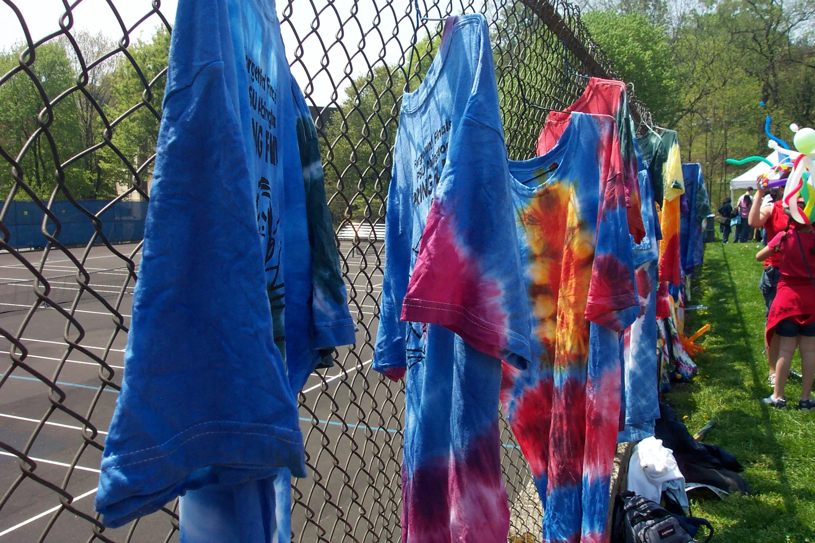Tie-dyed shirts line the fence above the tennis courts.