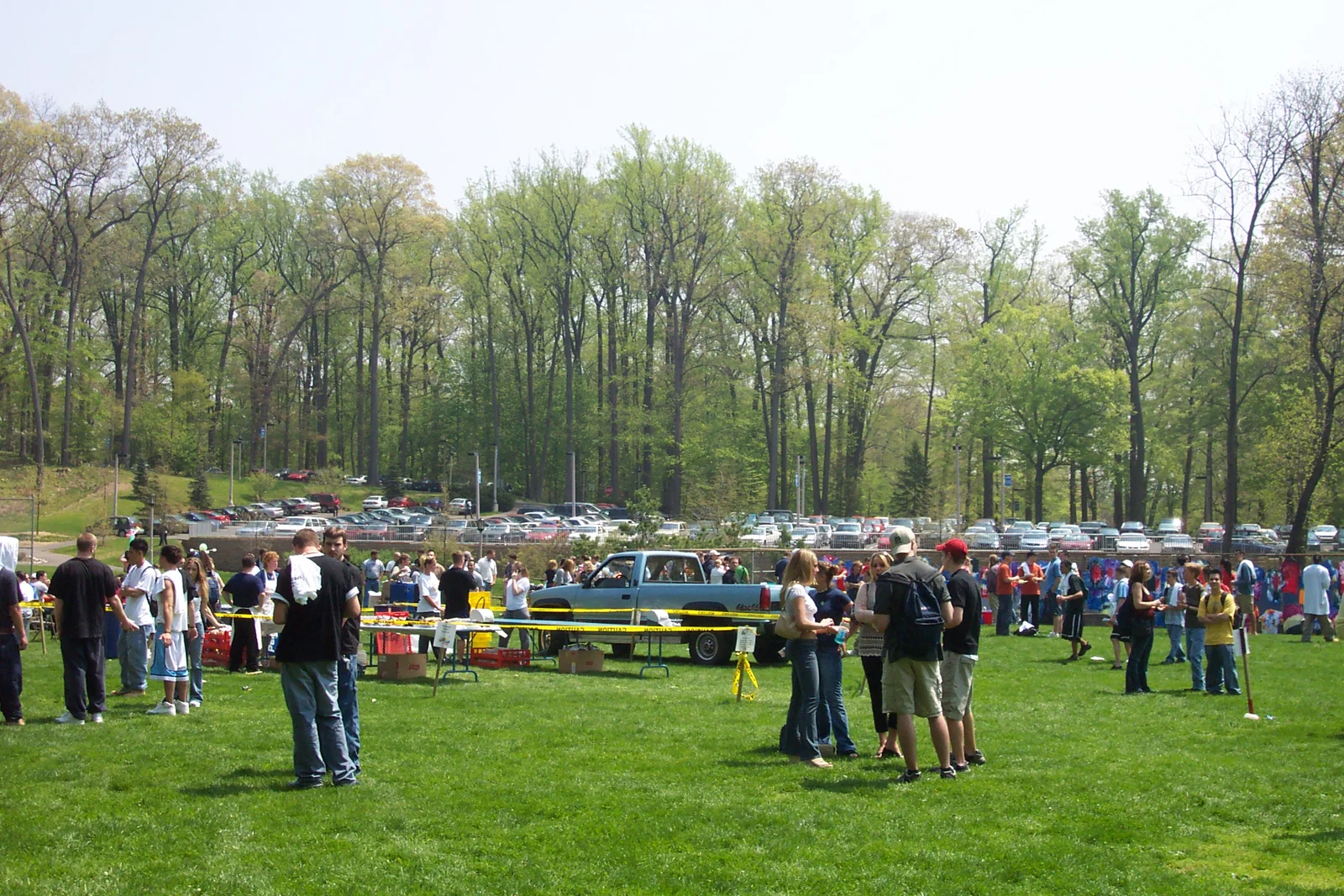 The spring trees in the background are in stark contrast to the parking lot below it. 