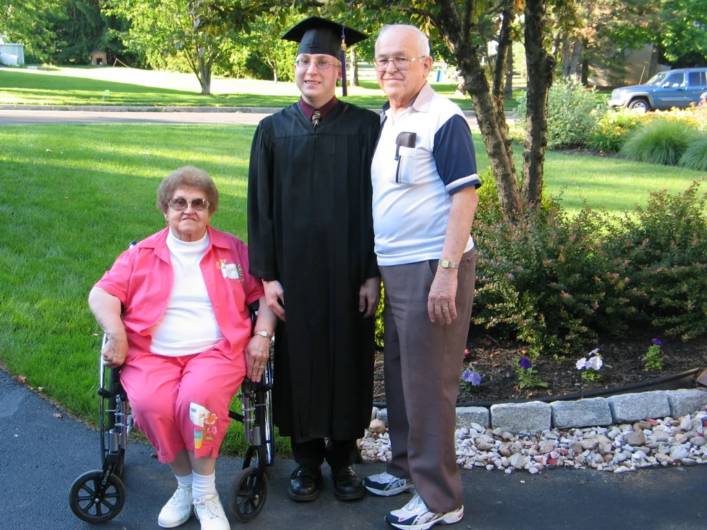 Chris poses with his father's parents, shortly before departing for the graduation ceremony.
