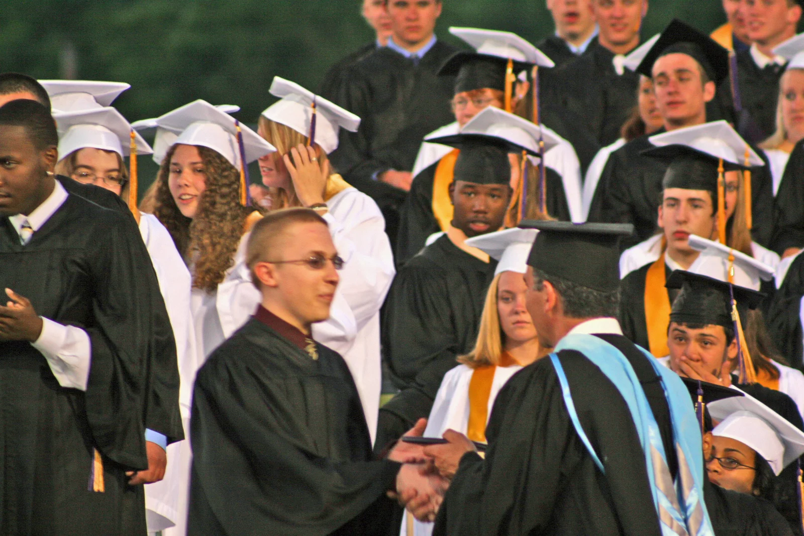 Chris shakes Michael Daher's hand after receiving his degree. 