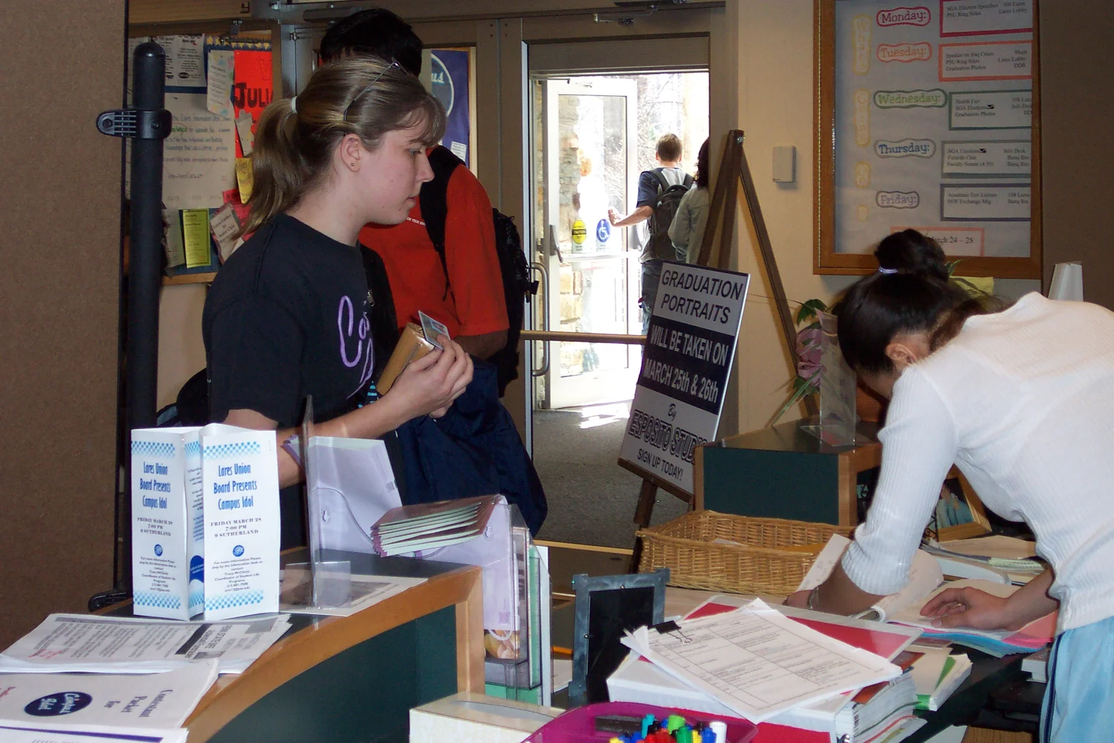 A student, with the help of Student Life Assistant Elaine, votes in the SGA elections. 