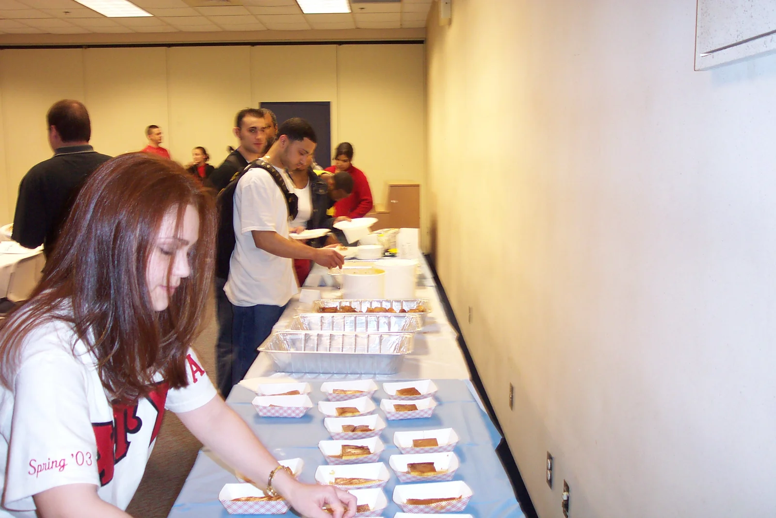 Jackie Vega adds more Spanish food to the table while those behind her quickly consume it. 
