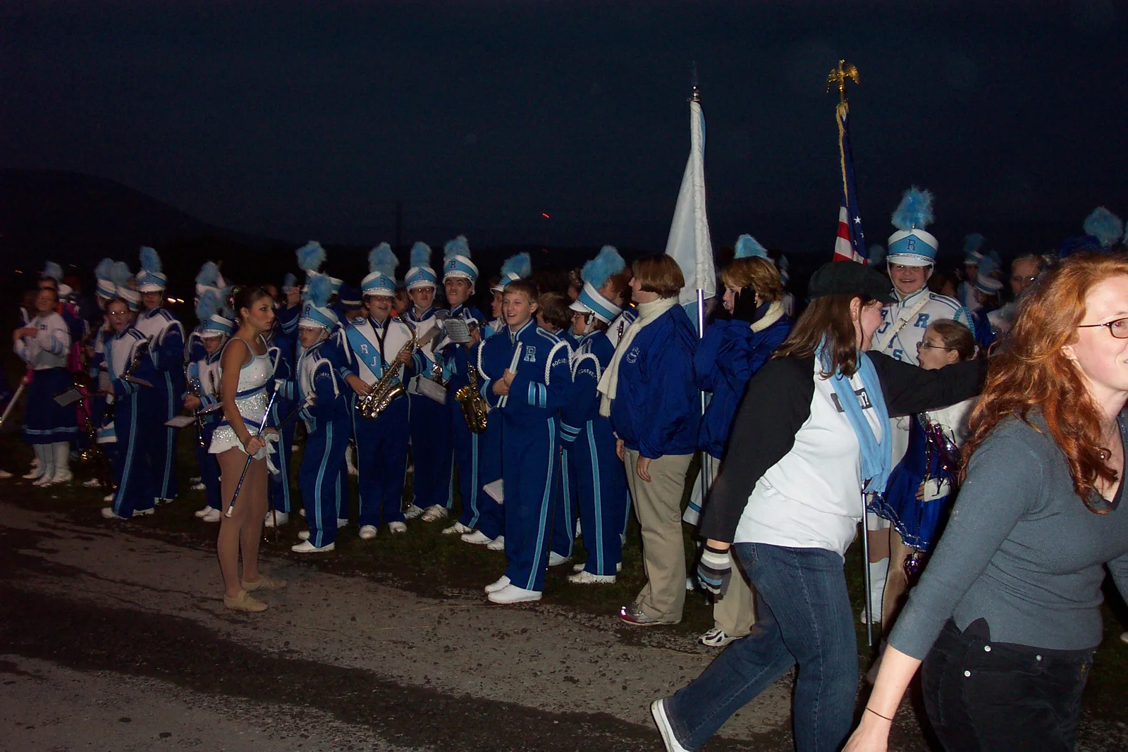 A high school marching band stands ready. 