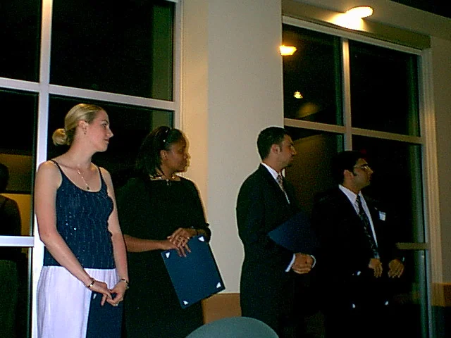 Kristina Amodei, Drew Lavenberg, Ninad Pendharkar, and another woman stand respectfully as they are honored. 