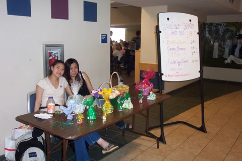 Mai Diep, President of the Asian Student Association, fundraises outside the performance with another club member.