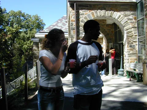 These students relaxed in front of the snowcone stand. 