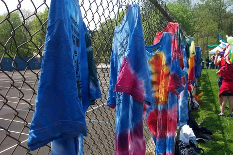 Tie-dyed shirts line the fence above the tennis courts.