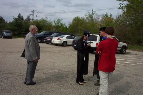 Sarah, Eric, her brother Joe, and her grandfather converse outside building K. 