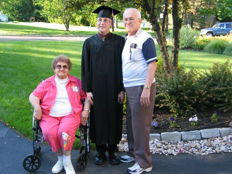 Chris poses with his father's parents, shortly before departing for the graduation ceremony.