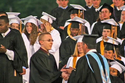 Chris shakes Michael Daher's hand after receiving his degree.