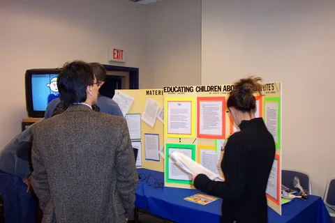Several staff members, including library staff member Binh Le, look at a poster. 