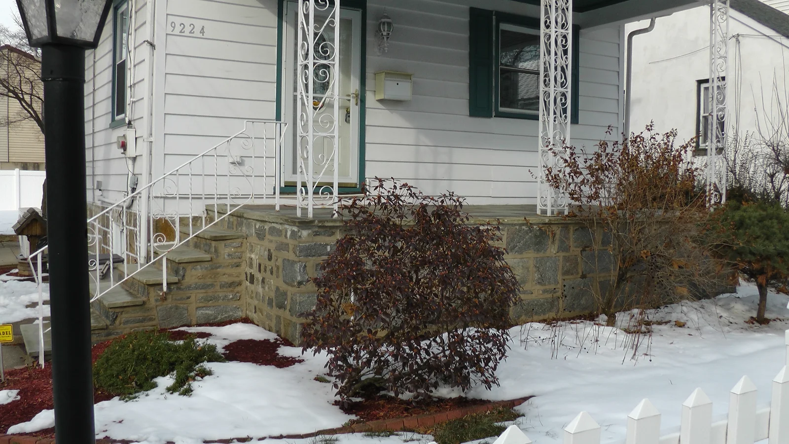 Beautiful landscaping lines the front porch and the edges of the property.