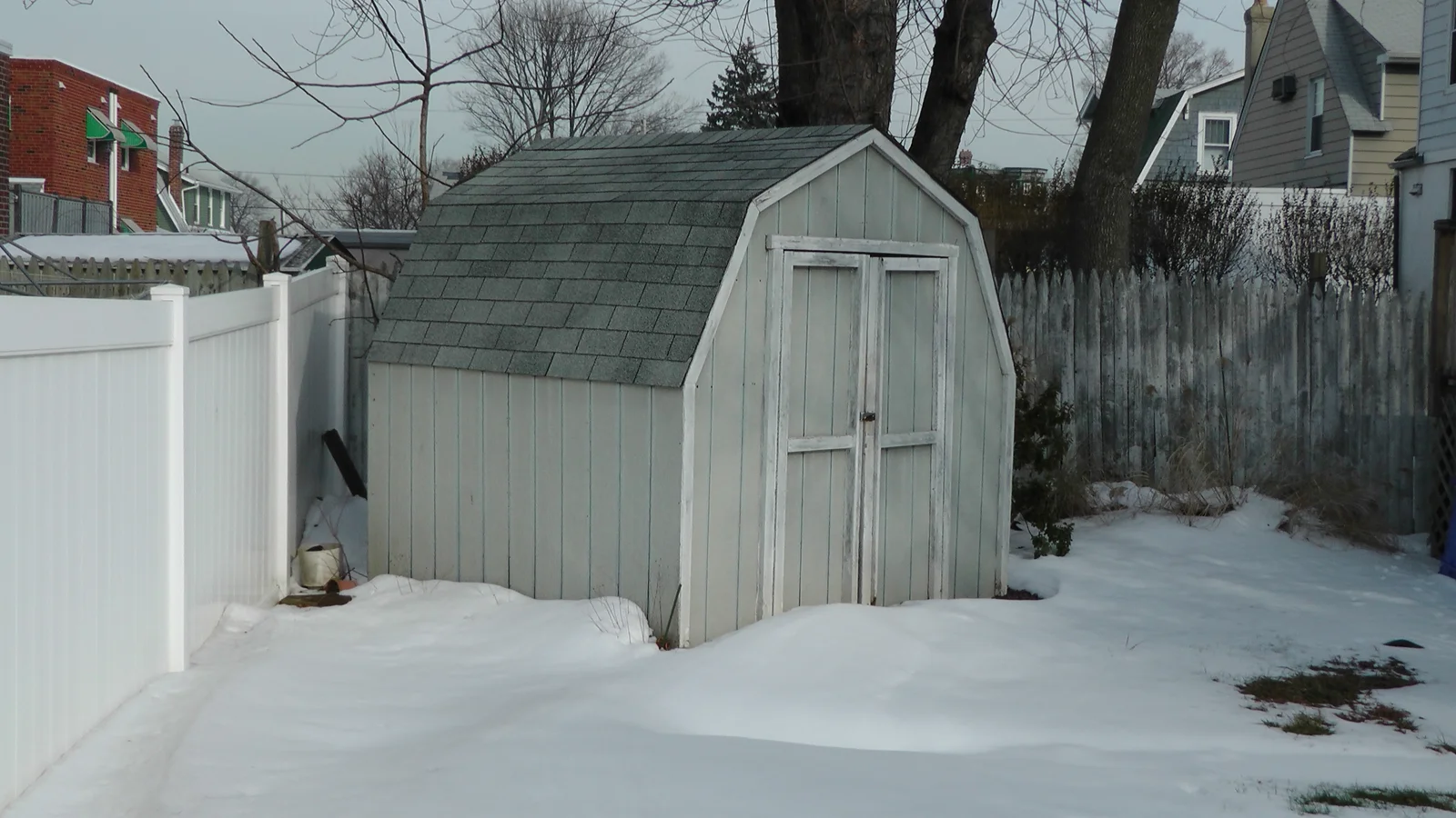 A locked shed in the backyard provides storage space.