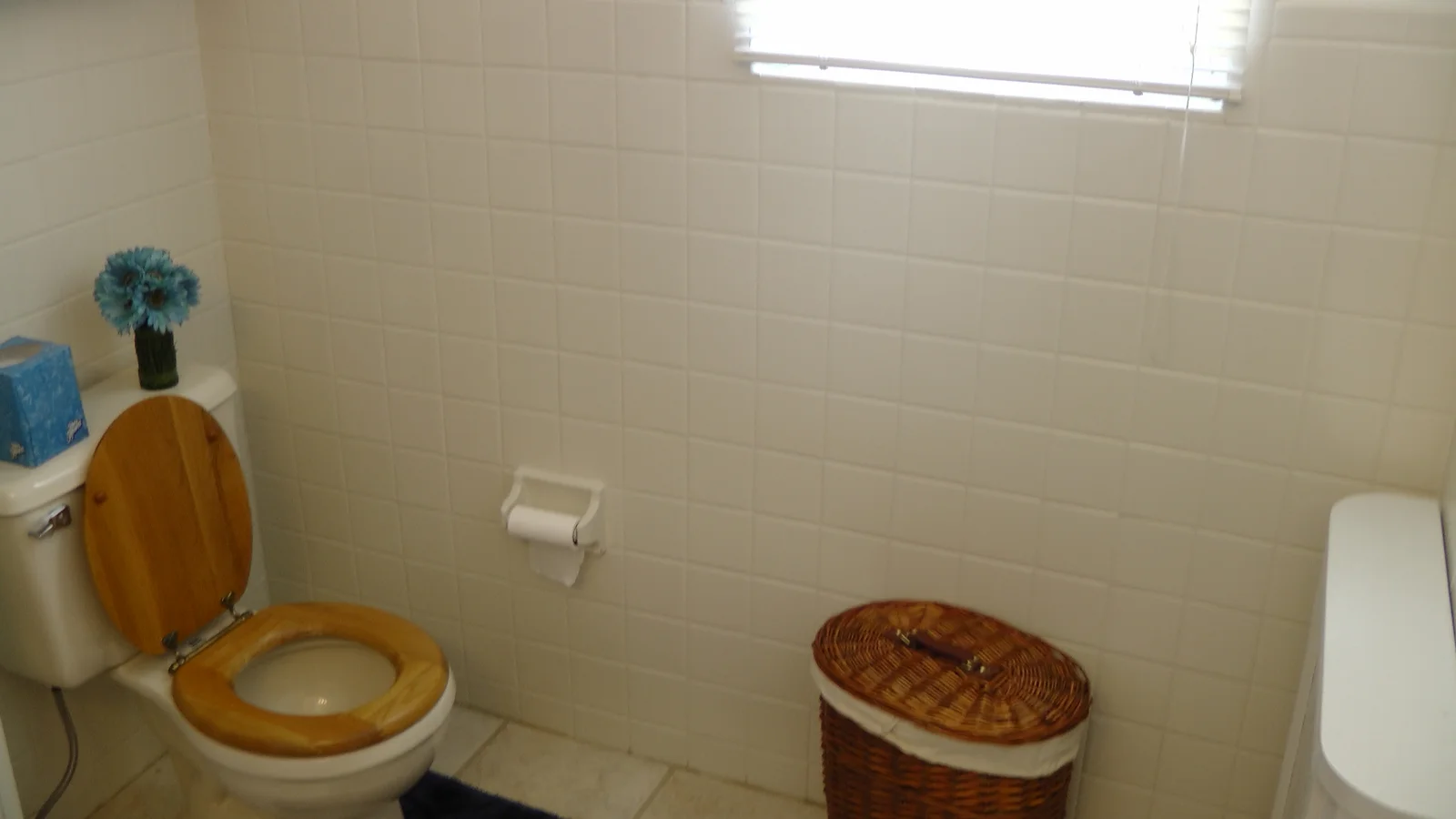 The bathroom is well lit by the outdoor lighting coming through the window.