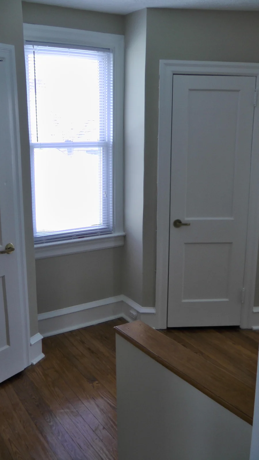 The second floor hallway, with two closets for storage and a window to illuminate the stairwell area with natural light.