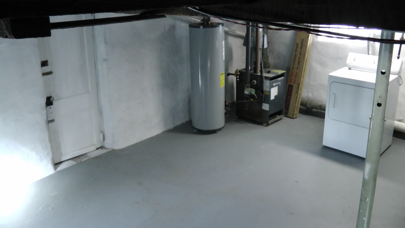 A wide shot of the basement, facing the water heater.