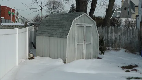 A locked shed in the backyard provides storage space.