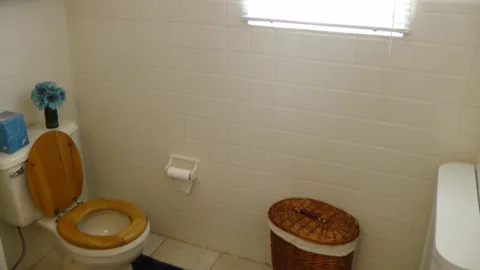 The bathroom is well lit by the outdoor lighting coming through the window.