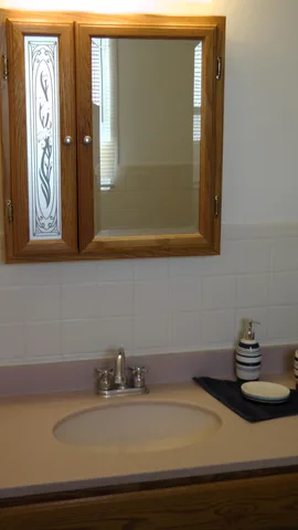 Pristine mirrors above the sink provide assistance to those preparing for a busy day.